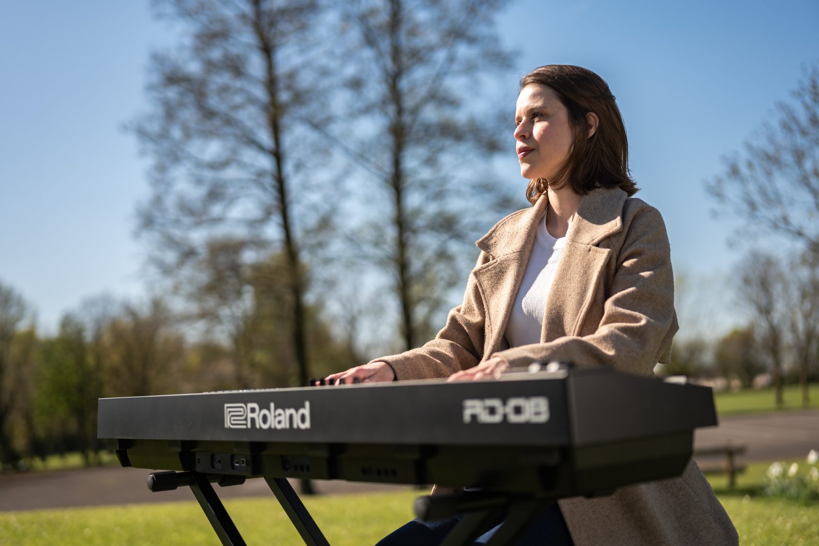 Nicoli Uzun playing keyboard outdoors, fully focused