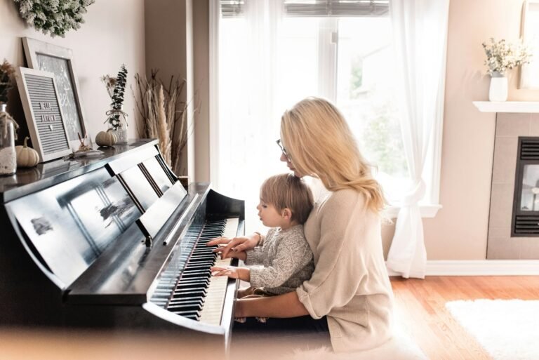 Mother and young child playing the piano together at home